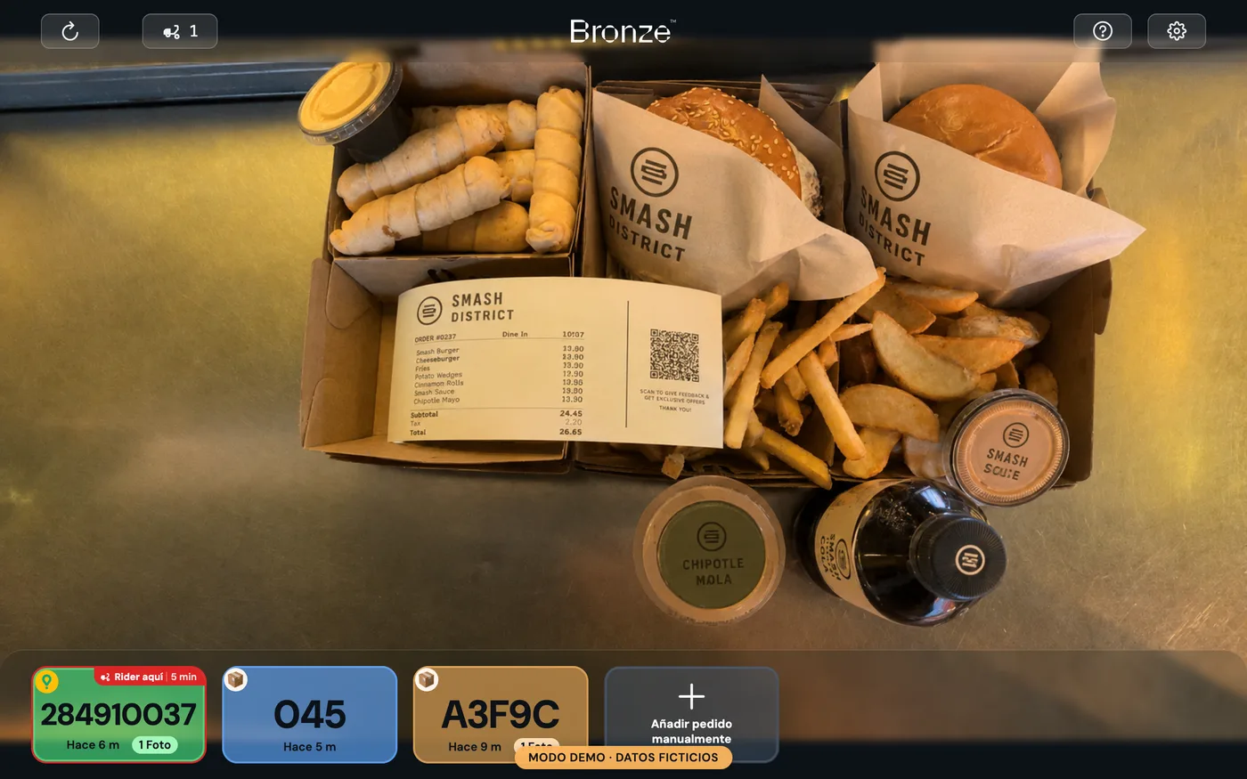 Bronze Tracker verificando un pedido en la mesa de salida de una cocina